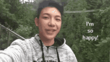 a young man is taking a selfie with the words `` i 'm so happy '' .
