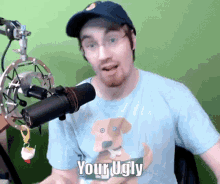 a man wearing a blue shirt with a dog on it says your ugly in front of a microphone