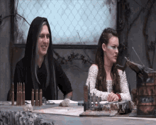 a man and woman sit at a table with bullets on it