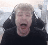 a man wearing headphones is yawning with his mouth open .