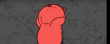 a red teddy bear is standing in front of a wall with a pattern on it .