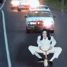 a woman is sitting on a tricycle in the middle of a street .