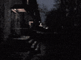 a dark street with a building in the background