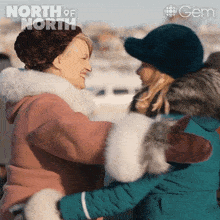 two women hugging each other with the words north of north behind them