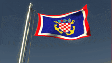 a red white and blue flag with an anchor and a crown on it