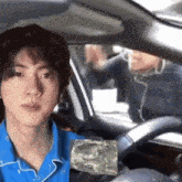 a man in a blue shirt sitting in a car