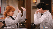 a man and a woman are giving each other a high five with a nbc logo in the corner