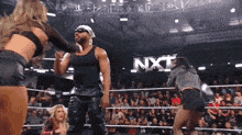 a wrestling match is going on in front of a nxt banner