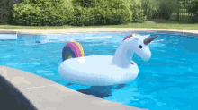a unicorn float in a swimming pool with a rainbow tail