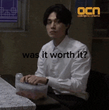 a man in a white shirt is sitting at a table with the words was it worth it