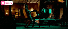 a woman is standing next to a man laying on a bed in a living room .