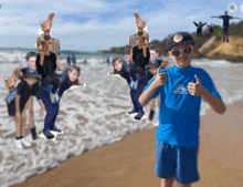 a boy wearing a blue shirt that says australian giving a thumbs up