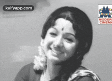 a woman is smiling in a black and white photo with a modern cinema logo behind her