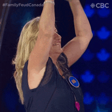 a woman raising her arms in the air with a badge that says win