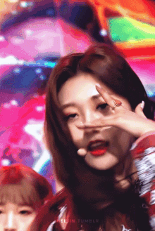 a close up of a girl 's face with a ring on her finger