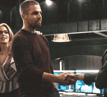 a man and a woman are standing next to each other in a room . the woman is hugging the man .