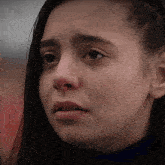 a close up of a woman 's face with a sad expression