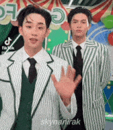 two men in suits and ties are standing next to each other in front of a sign that says tiktok