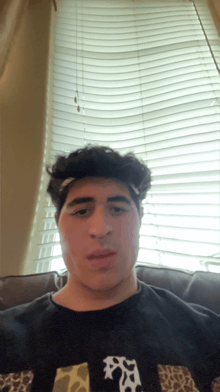a man with a bandage on his forehead looks at the camera