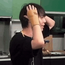 a man is holding his head with his hands while wearing a glove .