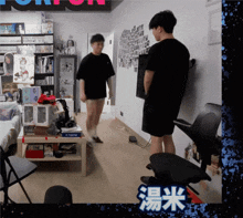 a man in a black shirt stands in a room with chinese writing