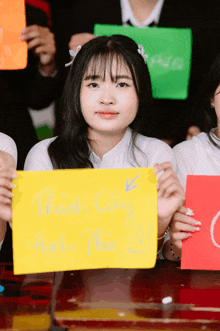 a girl is holding a yellow sign that says thank cong