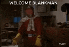 a man in a superhero costume is standing in a kitchen with the words welcome blankman above him .