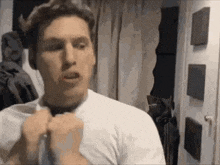 a man is applying lipstick to his lips while looking at himself in a mirror .