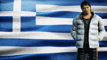 a man stands in front of a greek flag