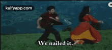 a man and a woman are dancing in a field and the man is holding a guitar .