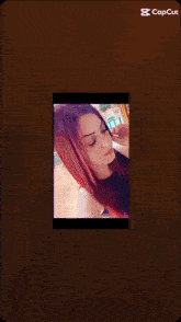 a picture of a woman with red hair is shown on a phone screen