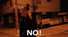 a woman says no while standing in front of a building at night