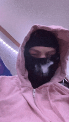 a person wearing a ski mask and a pink hoodie
