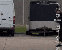 a white van is parked next to a trailer with the number 37 on the back .