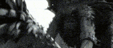 a black and white photo of a person with feathers on their face