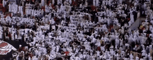 a large crowd of people are gathered in a stadium with a sign that says ' aggies ' on it
