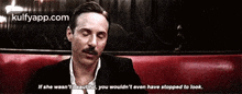 a man with a mustache is sitting on a red couch and says if she wasn 't beautiful