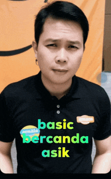 a man wearing a black shirt that says " basic berganda asik "