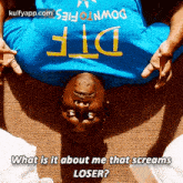 a man wearing a blue shirt that says dtf is laying on the floor