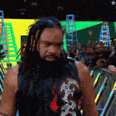 a man with dreadlocks is wearing a shirt that says ' smack down ' on it