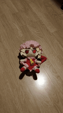 a stuffed doll is laying on a wood floor