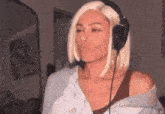 a woman wearing headphones is making a funny face .