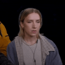 a woman in a blue jacket is making a surprised face .