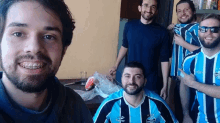 a group of men are posing for a picture and one of them is wearing a shirt that says topper on it