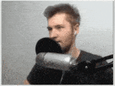 a man is singing into a microphone while wearing ear buds