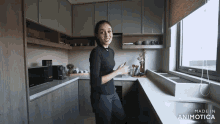 a woman standing in a kitchen with the words made in animatica on the bottom right