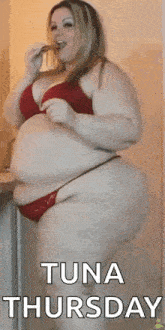 a very fat woman in a red bikini is eating a piece of food .