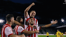 a soccer player with the number 23 on his back is being lifted by his teammates