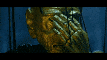 a gold statue of a man covering his mouth with his hands