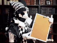 a person in a harlequin costume is holding a picture frame .